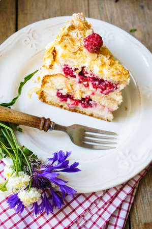 Almond cake with Raspberries on the plate and summertime flowers
