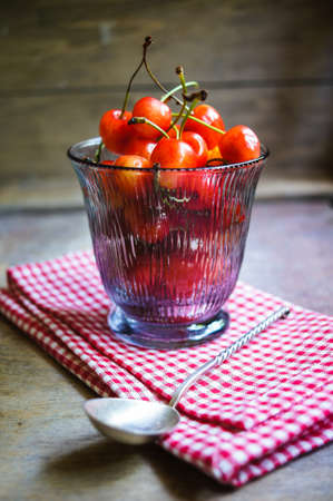 Ripe sweet cherries in the bowl on the rustic style old table