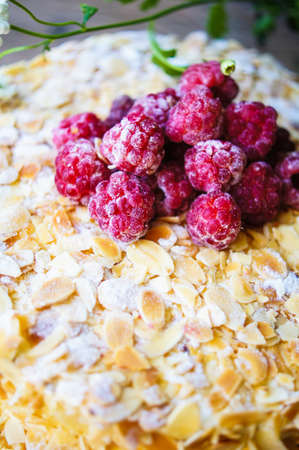 Almond cake with Raspberries on the plate and summertime flowersの写真素材
