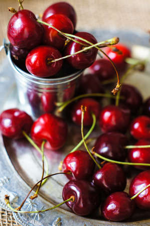 ripe sweet cherries in a bowl on a bright napkinの写真素材