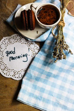 cup of black coffee with chocolate macaroon and lavender flowersの写真素材