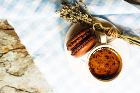 cup of black coffee with chocolate macaroon and lavender flowersの写真素材