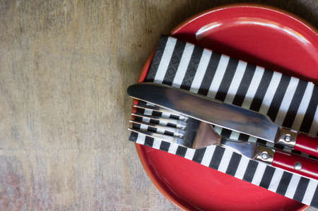 Table Setting with napkin and silverware on wooden table