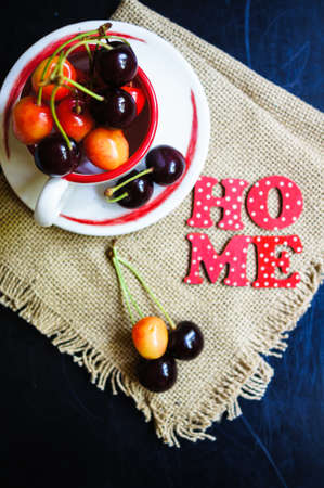 Ripe sweet cherries in the bowl on the rustic style old table