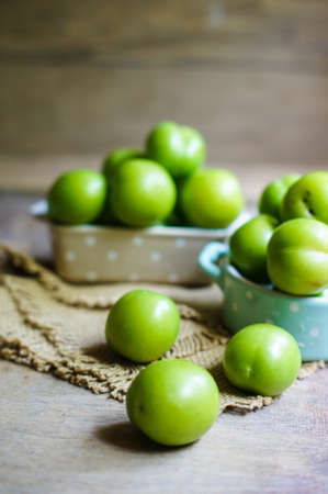 Green cherry-plum in vintage bowl, selective focusの写真素材