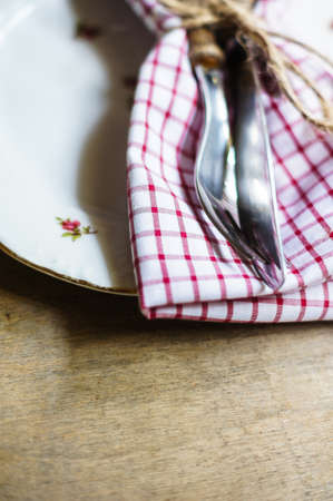 Table Setting with napkin and silverware on wooden table