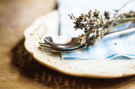 Rustic Table Setting with napkin, silverware and dry lavendre lowers on old wooden tableの写真素材