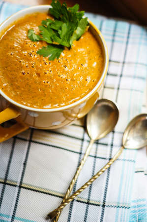 Homemade tomato and basil soup with parmesan cheese in  bowl and vintage spoon