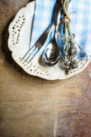 Rustic Table Setting with napkin, silverware and dry lavendre lowers on old wooden tableの写真素材