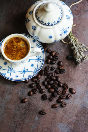 Vintage cup with black coffee, dry lavender flowers and coffee beans