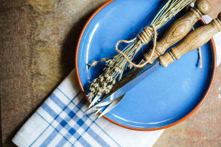Rustic Table Setting with napkin, silverware and dry lavendre lowers on old wooden table
