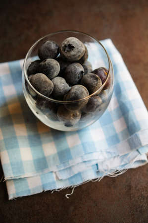 Fresh organic blueberries covered with frost in the bowl on the vintage stone tableの写真素材