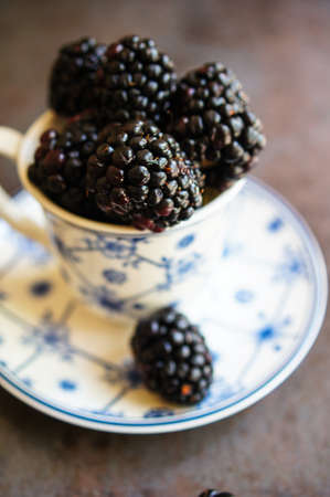 Sweet blackberries in the vintage cup on the dark backgroundの写真素材