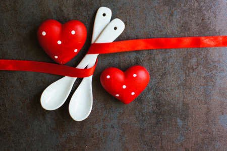 Table set for celebration St. Valentine's Day with red ribbin on dask stone backgroundの写真素材