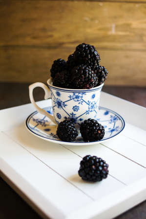 Sweet blackberries in the vintage cup on the dark backgroundの写真素材