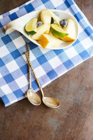Fresh Organic Fruit Salad in a bowl with vintage spoon on the bright napkinの写真素材
