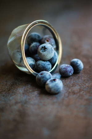 Fresh organic blueberries covered with frost in the bowl on the vintage stone tableの写真素材