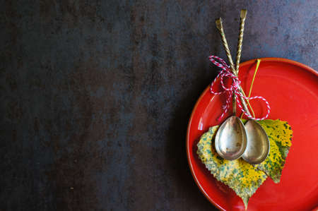 Autumnal table setting with vintage table silverware and yellow leavesの写真素材