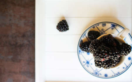 Sweet blackberries in the vintage cup on the dark backgroundの写真素材