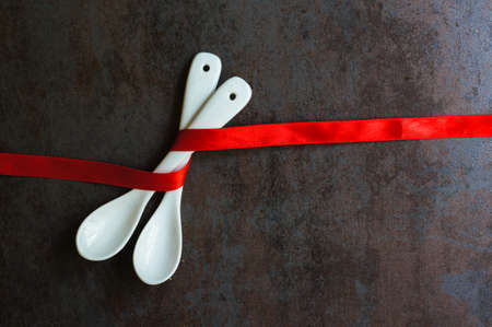 Table set for celebration St. Valentine's Day with red ribbin on dask stone backgroundの写真素材