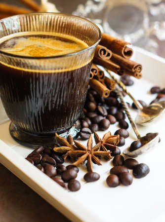 Glass of coffee and christmas time festive decoration on the dark backgroundの写真素材