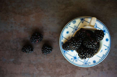 Sweet blackberries in the vintage cup on the dark backgroundの写真素材