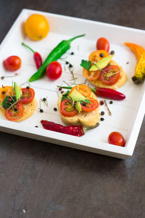 Bruschetta with tomato, avocado, chilli peper and herbsの写真素材