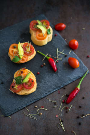 Bruschetta with tomato, avocado, chilli peper and herbsの写真素材