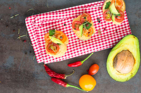 Bruschetta with tomato, avocado, chilli peper and herbsの写真素材