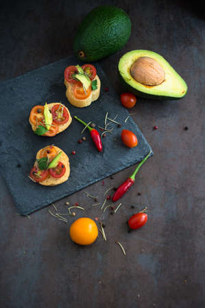 Bruschetta with tomato, avocado, chilli peper and herbsの写真素材