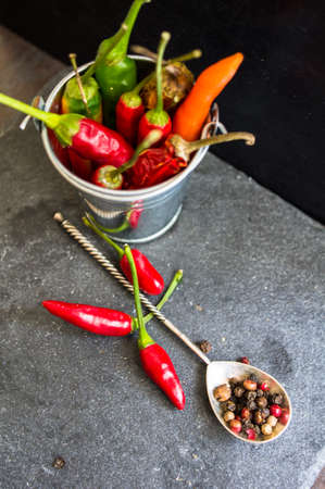 Spicy chili peppers on the black background. Selective focus