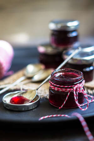 fruity jam and vintage spoons on the old black stone backgroundの写真素材
