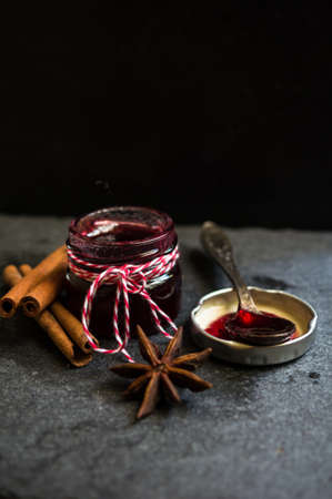 fruity jam and vintage spoons on the old black stone background