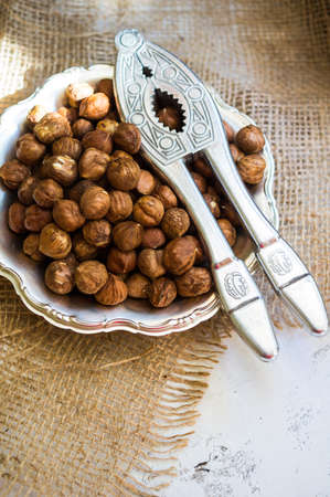 Hazelnuts in a bowl on rustic wooden background. Selective focus