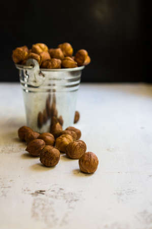 Hazelnuts in a bowl on rustic wooden background. Selective focus