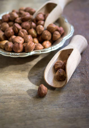 Hazelnuts in a bowl on rustic wooden background. Selective focusの写真素材