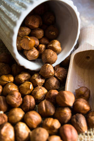 Hazelnuts in a bowl on rustic wooden background. Selective focusの写真素材