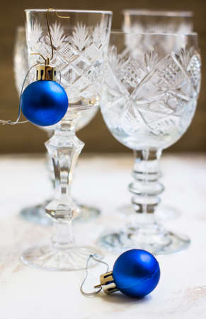Vintage crystal glasses on the black tray with christmas decorations. Selective focus