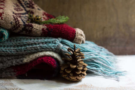 Knitted scarfs and hoodie on the rustic background