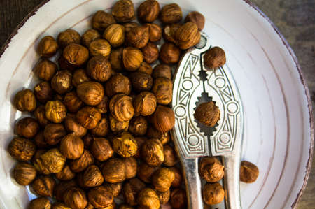 Hazelnuts in a bowl on rustic wooden background. Selective focusの写真素材