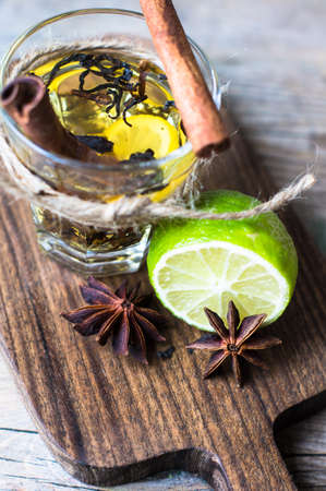 Glass of tea with lemon, cinnamon and anise on the rustic backgroundの写真素材