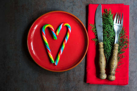 Table setting for Christmas eve with sweets and fir tree branchの写真素材