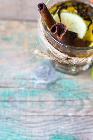 Glass of tea with lemon, cinnamon and anise on the rustic backgroundの写真素材