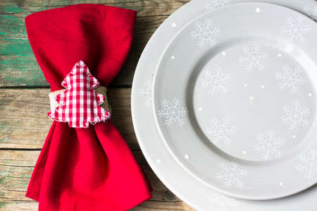 Rustic christmas table setting with bright plates and silverware