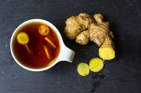 Cup of tea with ginger, cinnamon sticks and anise star spice on the rustic backgroundの写真素材