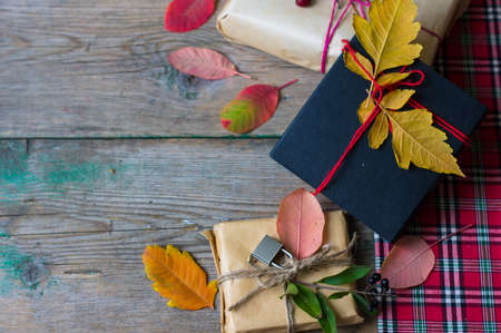 Present box decorated with autumnal yellow leaveas and berries on rustic backgroundの写真素材
