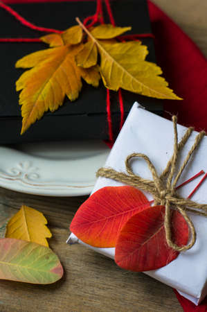 Rustic autumnal table setting with yellow leaves and berriesの写真素材