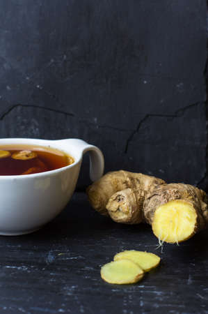Cup of tea with ginger, cinnamon sticks and anise star spice on the rustic backgroundの写真素材