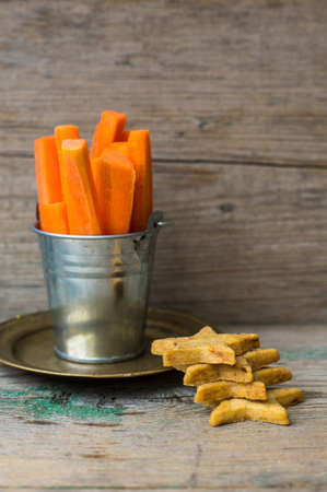 Fresh carrot sticks and carrot cookies on the old wwoden tableの写真素材