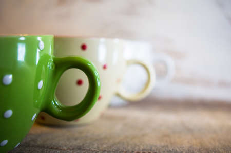 Multi colored empty big polka dot bowls on the wooden table in rustic styleの写真素材